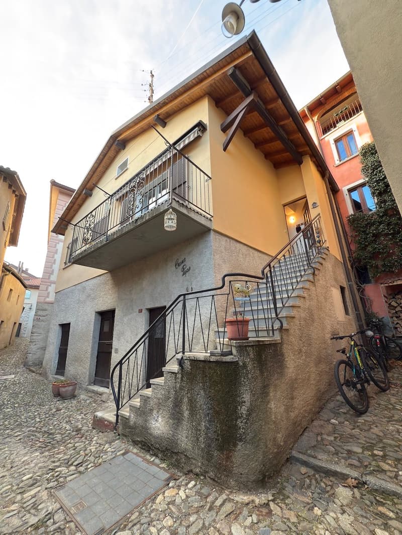 House with terrace, built with stone and bricks, iron stairs, and balconies