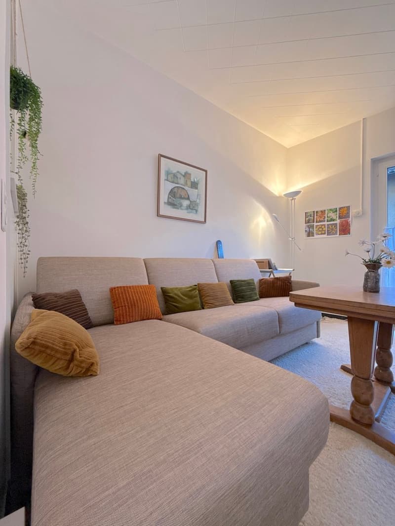 living room with sofa, coffee table, and painting on the wall