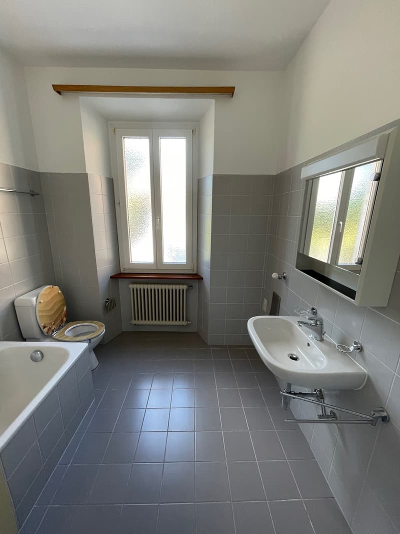 Bathroom with sink, bathtub, toilet, window, mirror