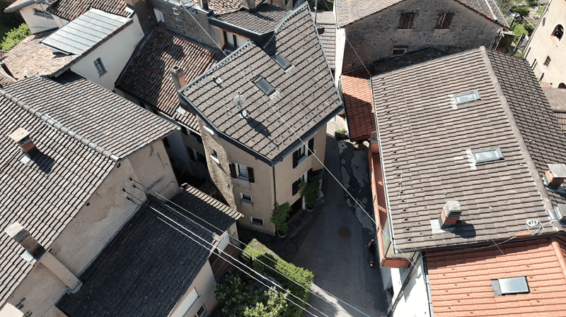 Aerial view of a row of houses with tiled roofs, chimneys, and windows