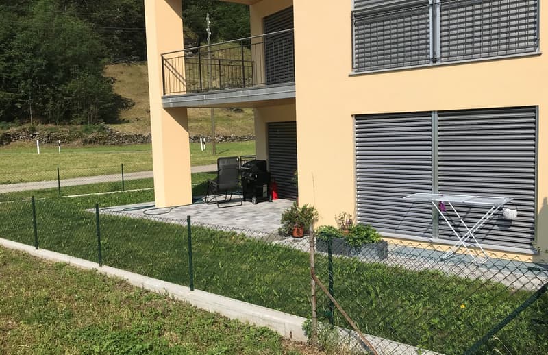2 story house, beige walls, balcony, garage, fenced yard, grill, plants, ironing board