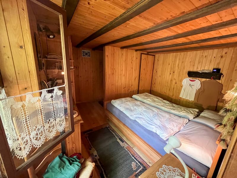 room with wooden walls, 3 beds, rug, lamp, wardrobe, framed picture