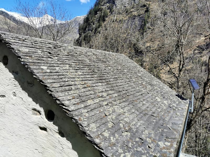 stone roof, white walls, mountains in background