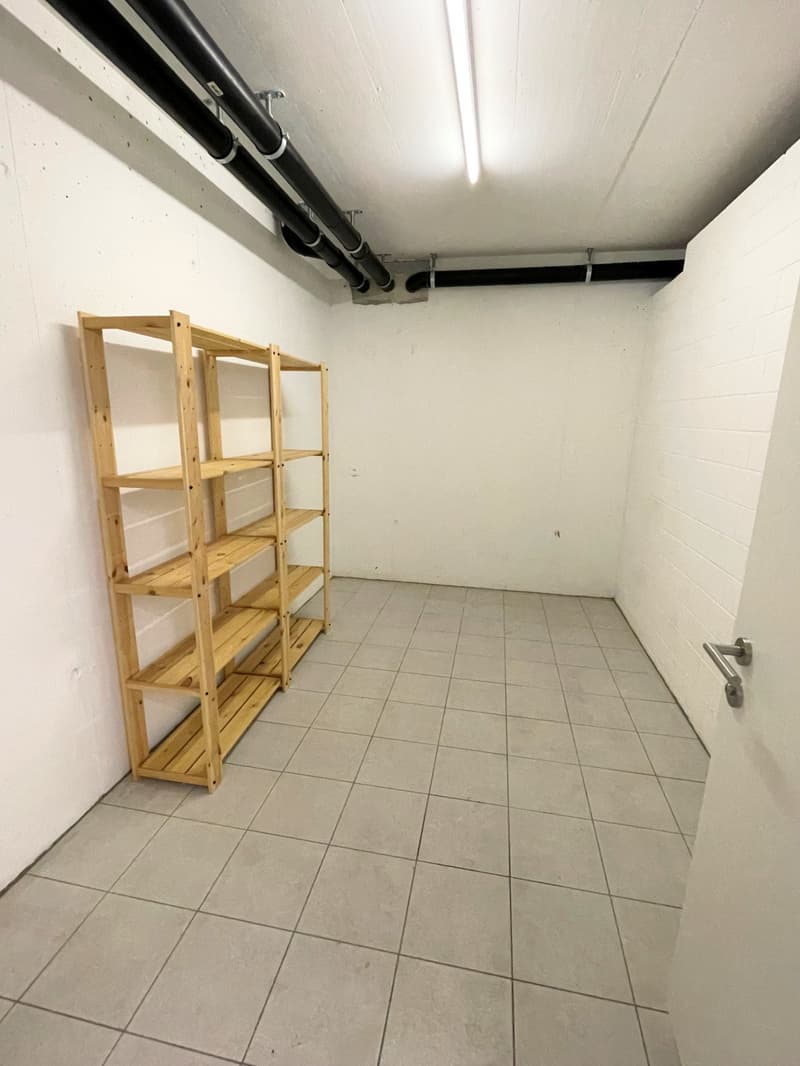 empty room, white tiled floor, wooden shelf against the wall, pipes on the ceiling