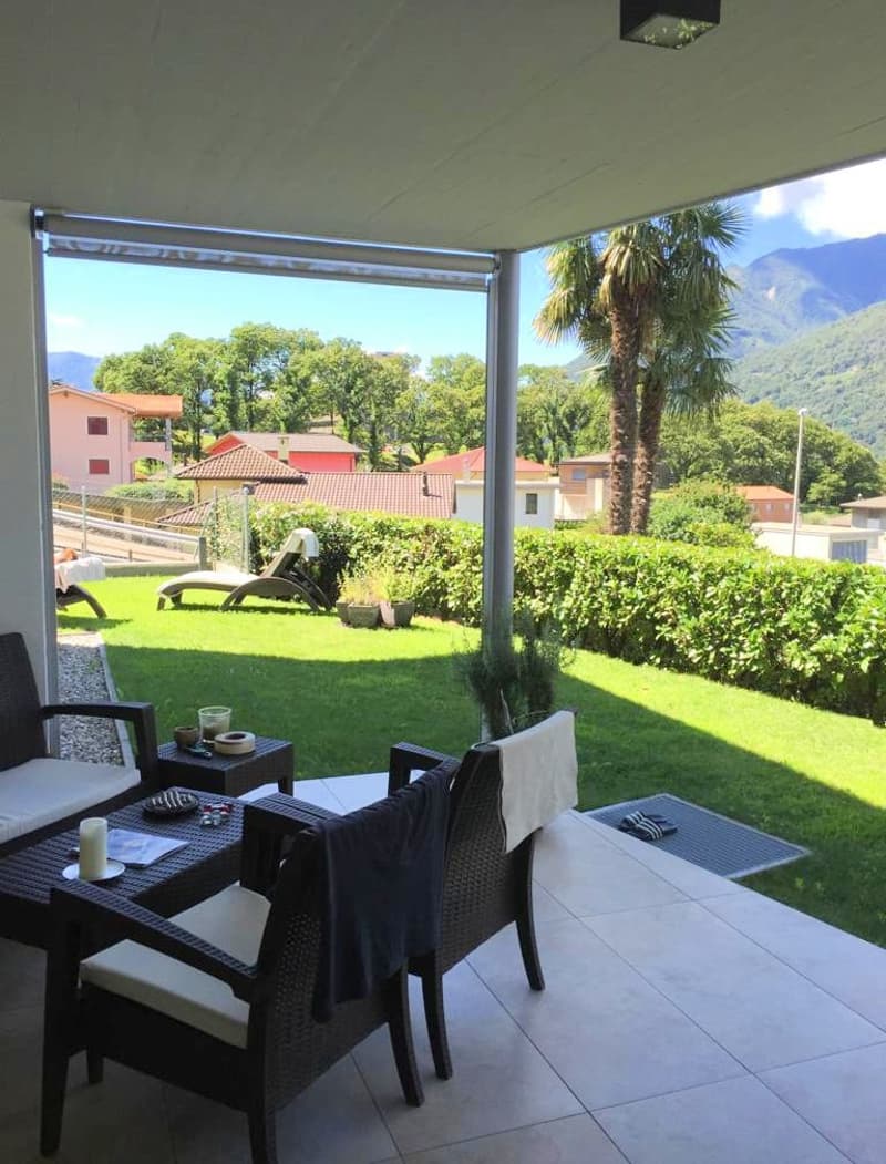 covered outdoor patio, chairs, table, lounge chairs, garden, palm tree, mountains in the background