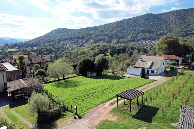 Rustic farmhouse with large plot, mountains in the background