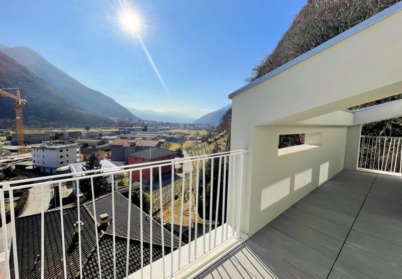 White building exterior, balcony with white railing, wooden deck flooring, view of the city and mountains