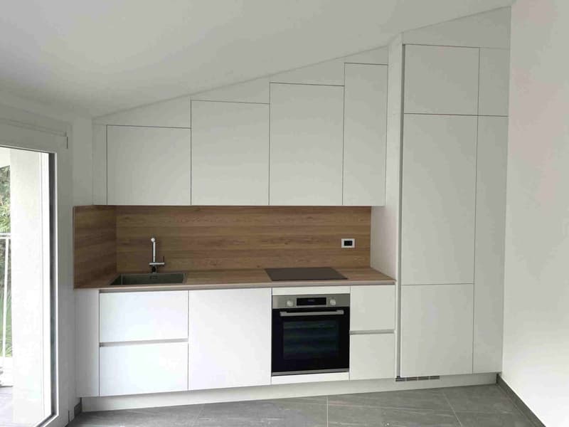open kitchen with white cabinets, wooden countertop, sink, oven, and natural light