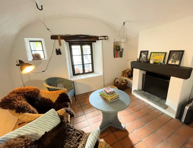 vaulted ceiling, fireplace, small windows, woven chair, wicker sofa with fur blanket