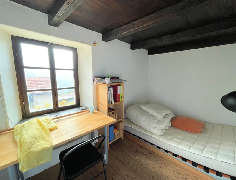 small room with bed, desk, chair, window, wooden ceiling