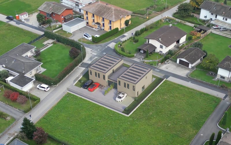 Modern residential complex with solar panels, multiple buildings, and parking areas.