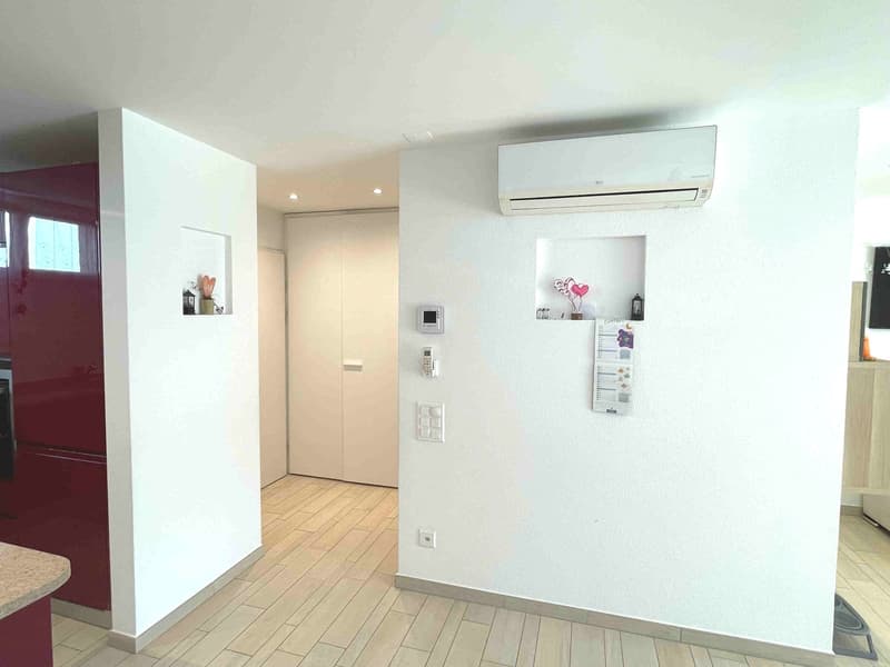 white walls, wooden floor, white ceiling, white air conditioner, white sliding door, red cabinet, white shelves, white switches and sockets