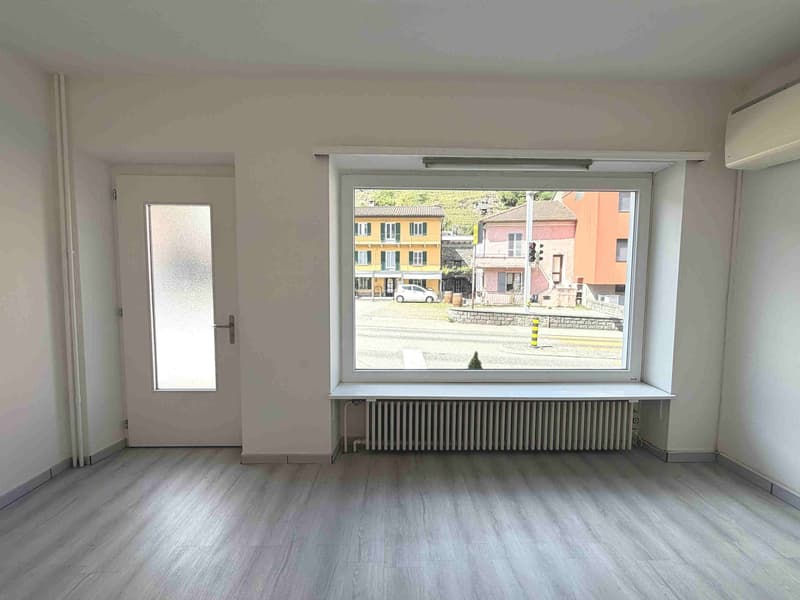 empty room, white walls, wooden floor, large window, white door, radiator