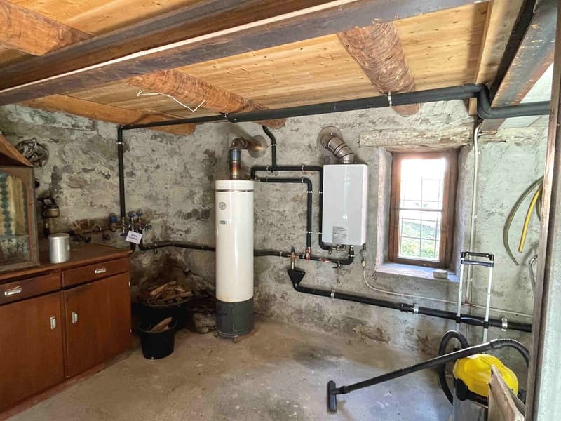 wooden ceiling, stone wall, water heater, gas heater, wooden cabinet, window, buckets, firewood
