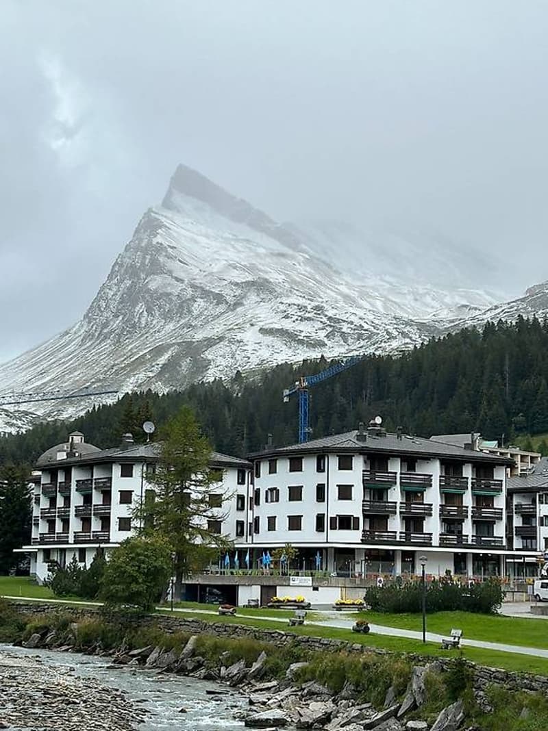 An apartment complex with 3 stories and a mountain in the background