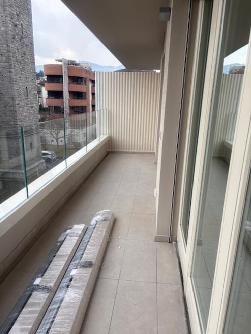Tiled floor, glass railing, and transparent glass walls, empty, open balcony, sliding glass doors, distant building