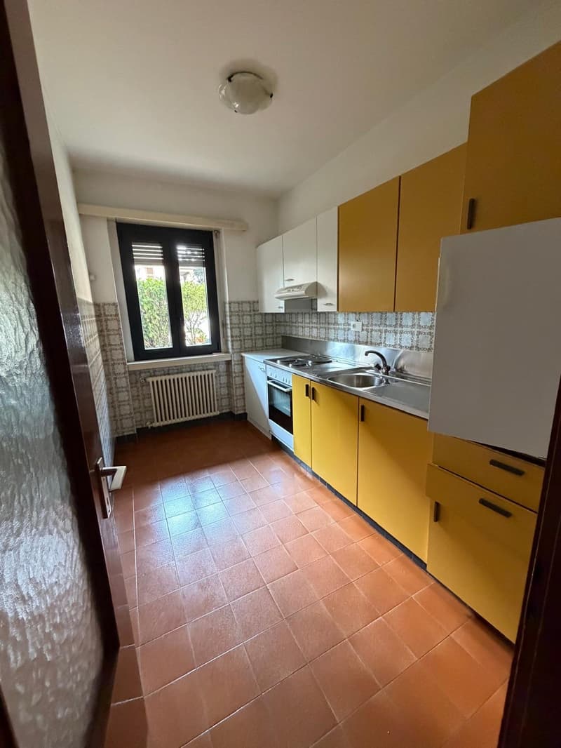 modern kitchen with wooden cabinets, tiled flooring, window, stove, sink, refrigerator