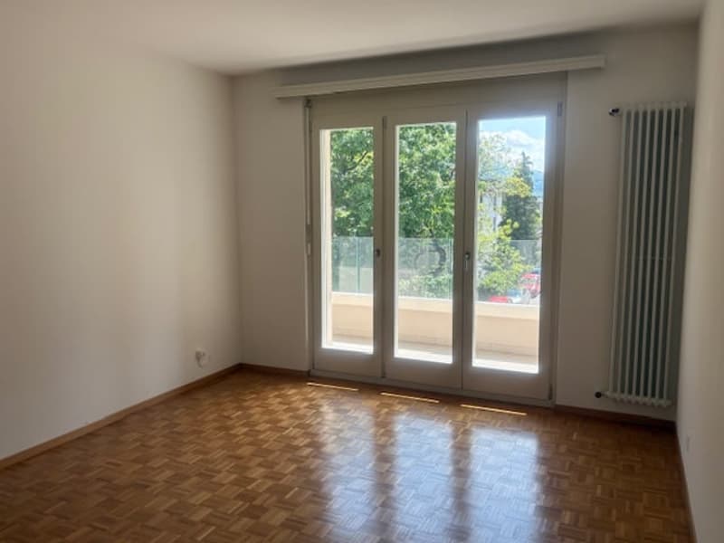 empty room, wooden floor, white walls, sliding glass doors, balcony, radiator
