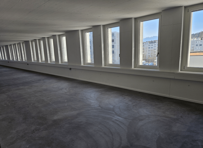 empty room, grey flooring, 5 large windows, view of cars