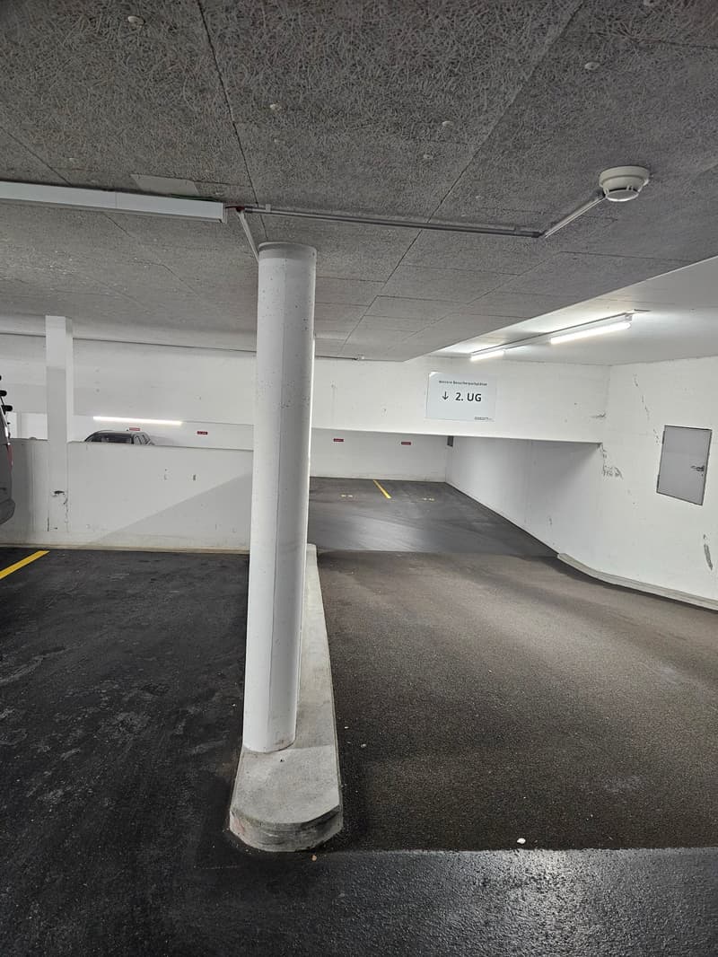 underground parking space, pillar, white walls, yellow markings