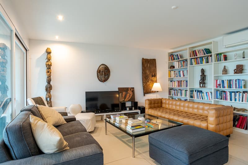 modern design living room, floor to ceiling windows, large sofas, coffee table, bookshelves, fireplace
