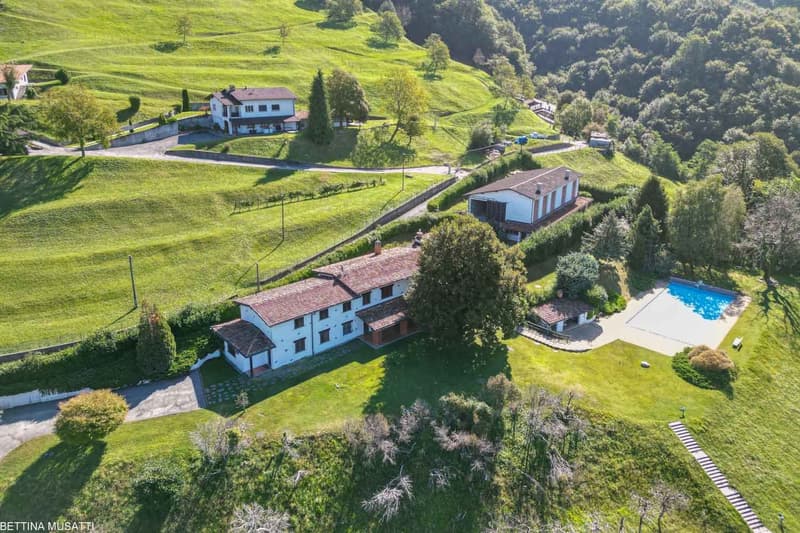 Villa with swimming pool in a scenic, hilly landscape with expansive green fields