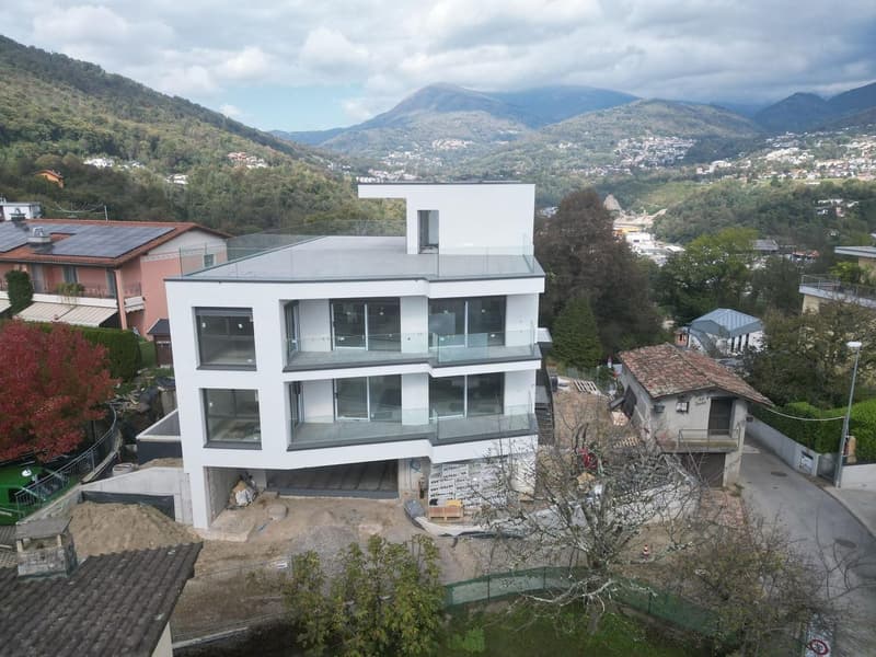 Newly built modern white house, glass balconies, open view of the mountains, unfinished road