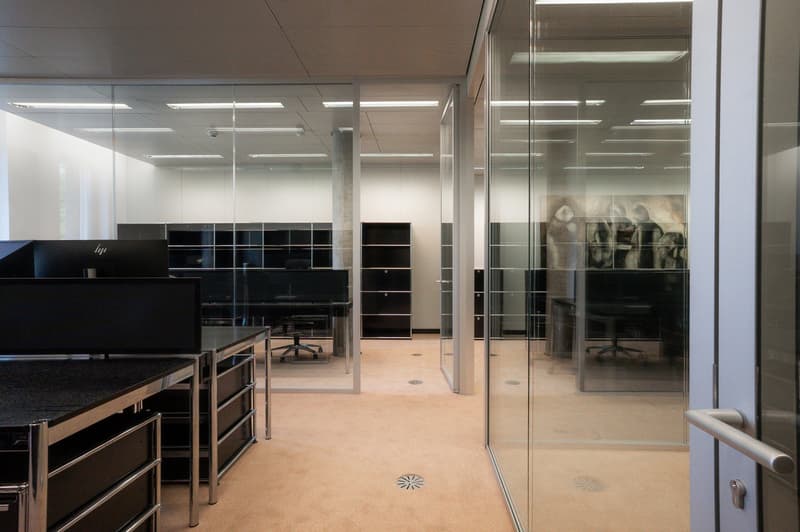 open space office with glass walls, beige floor, modern design, multiple glass doors