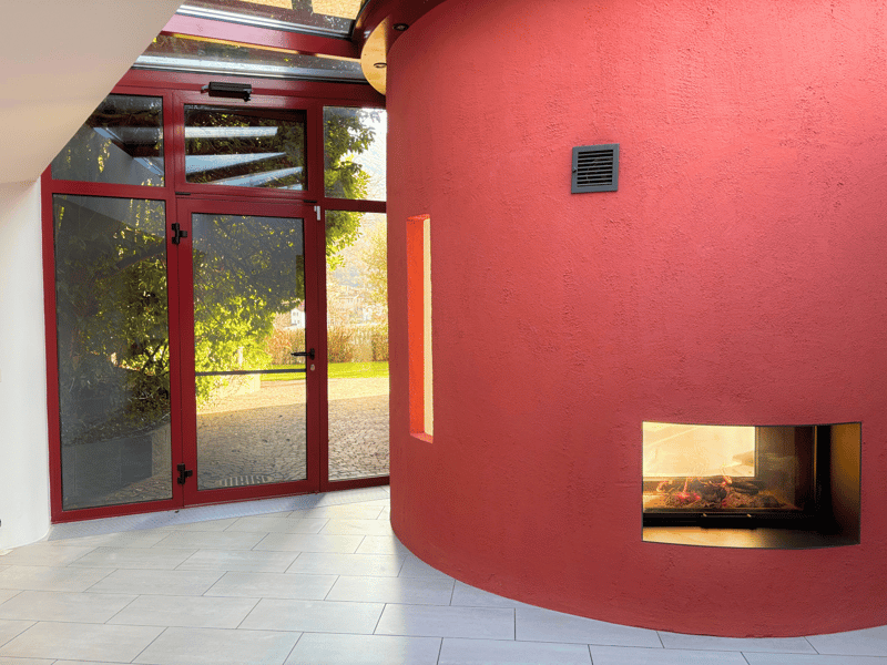 Entrance to the room with sliding glass doors, red walls, fireplace, tile floor