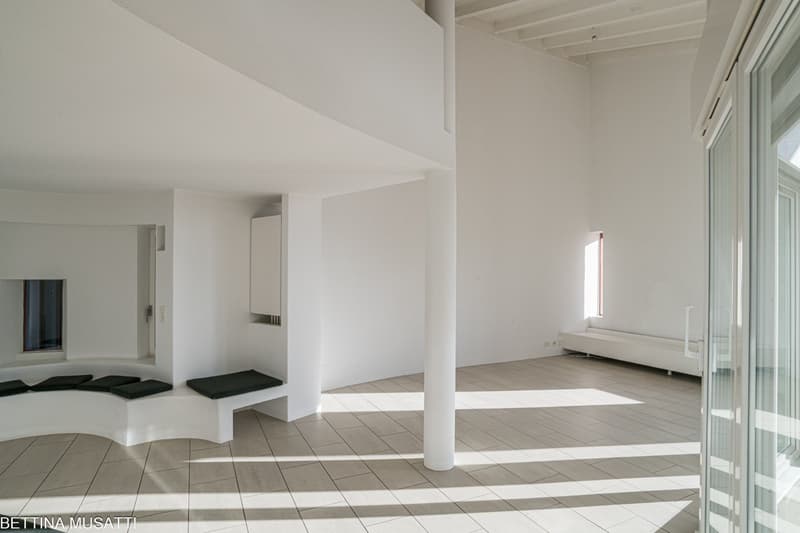 Minimalist room with white walls, tiled floor, built-in seating, open windows