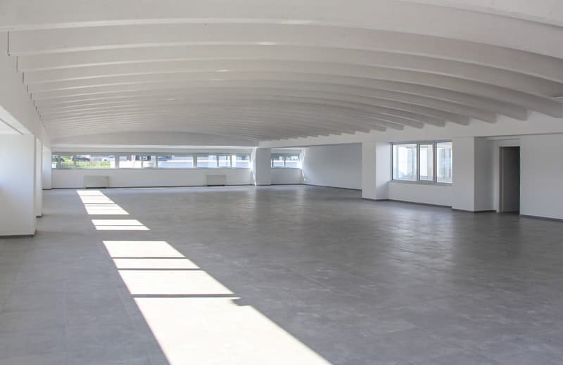 large room, empty, tile floor, curved ceiling, white walls, windows