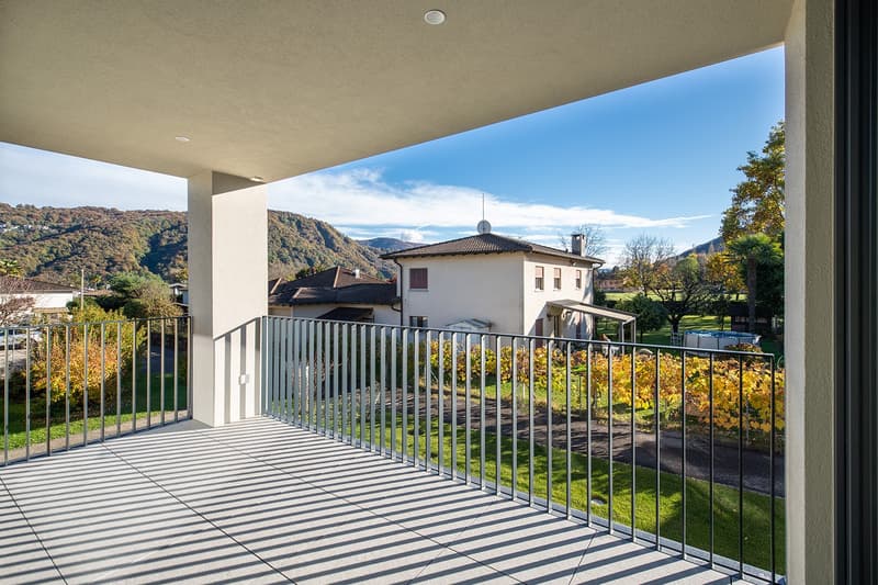 large balcony with metal railings, tiled floor, view of mountains and house