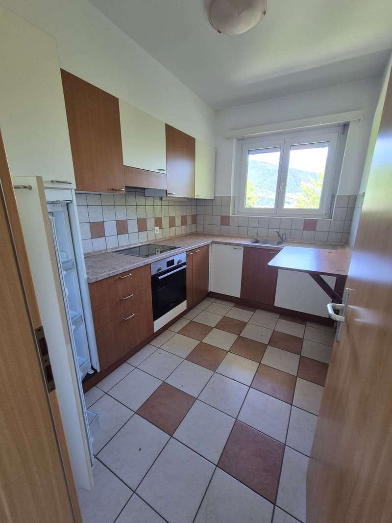 Spacious kitchen with brown and white cabinets, tiled floor, built-in oven, and a dishwasher
