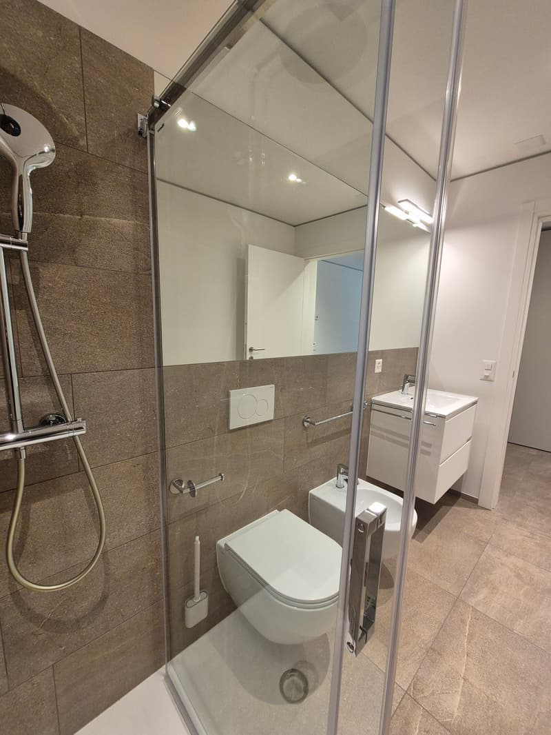 Bathroom with toilet, bidet, glass shower enclosure, and a vanity unit