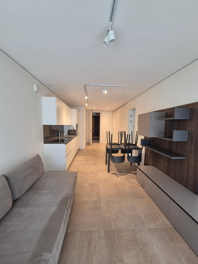 open floor plan, tile flooring, white cabinetry, large couch, dining table and chairs