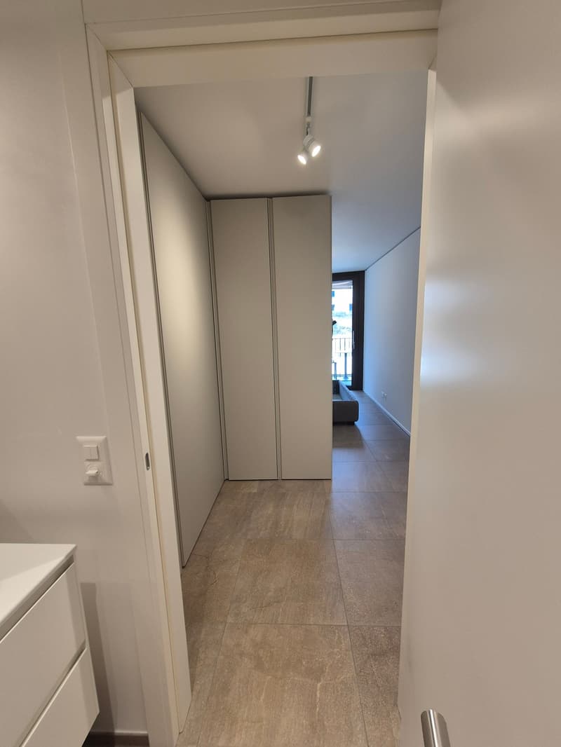 open corridor, beige tiles, large closets, bed in the corner