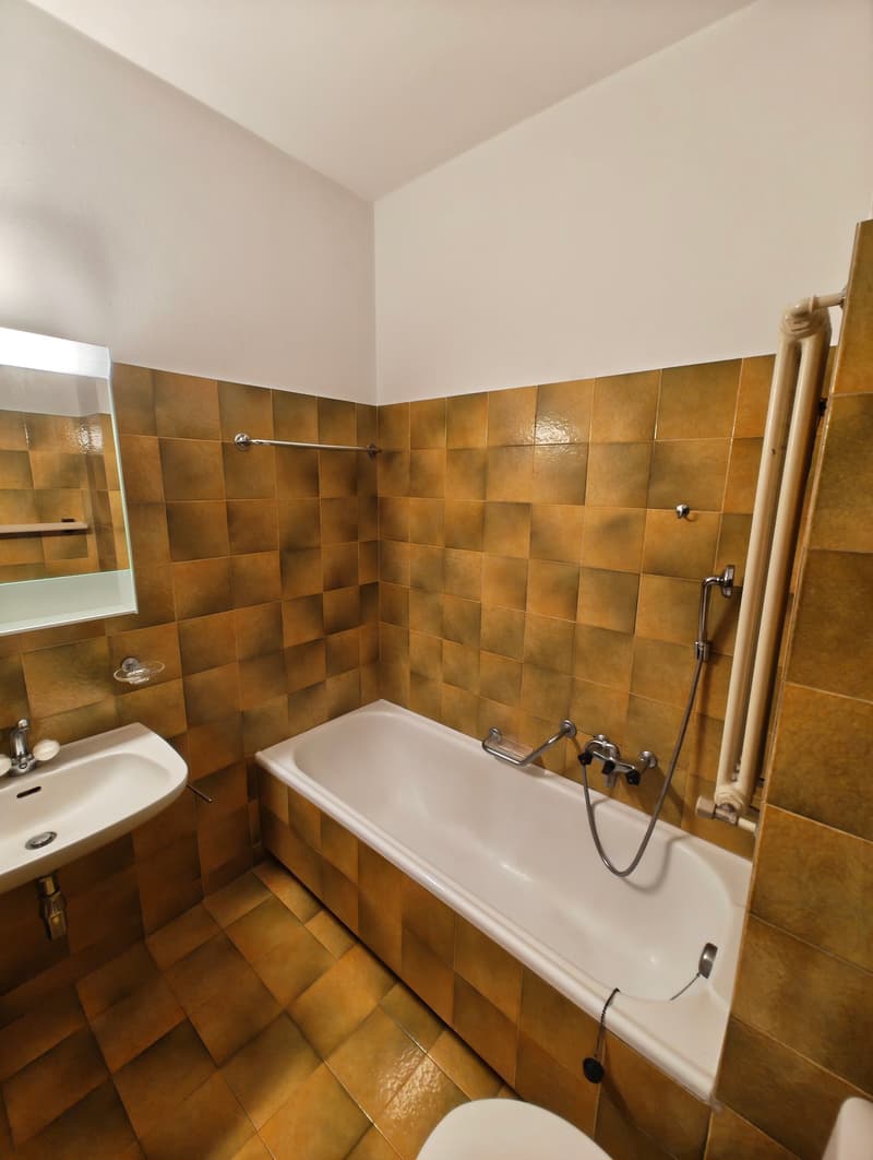 Bathroom with bathtub, sink, mirror, and toilet
