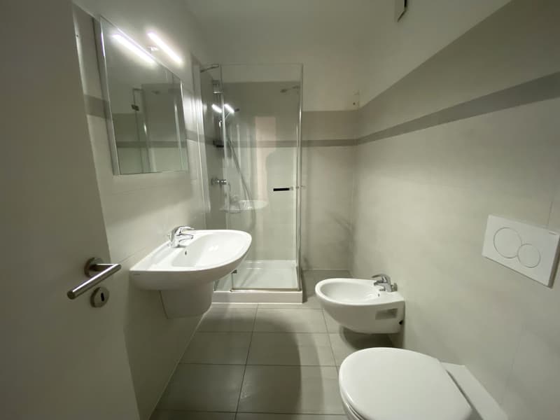 white tiled floor, a sink with a mirror, a shower, a bidet, a toilet, a power outlet