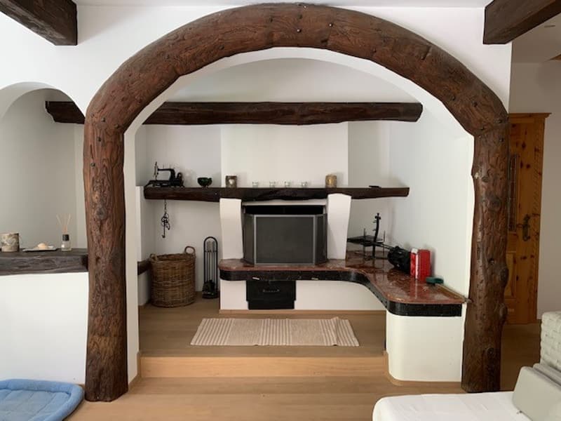 wooden beams, white walls, fireplace, flat screen TV, counter, basket, rug, bed, basket
