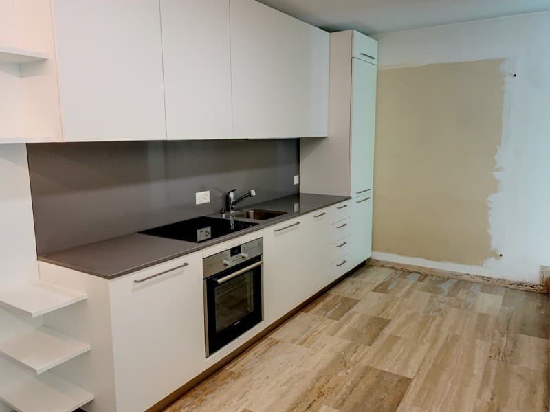 modern kitchen, white cabinets, granite countertops, under-mount sink, stove, oven, wooden floor