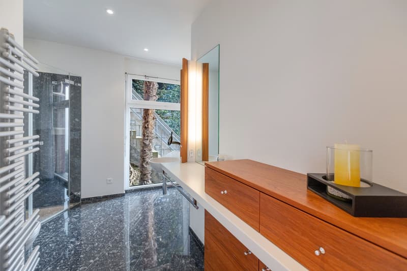 modern bathroom, walk-in shower, vanity with sink, wooden cabinet, large mirror, glass door, white walls, granite tiles