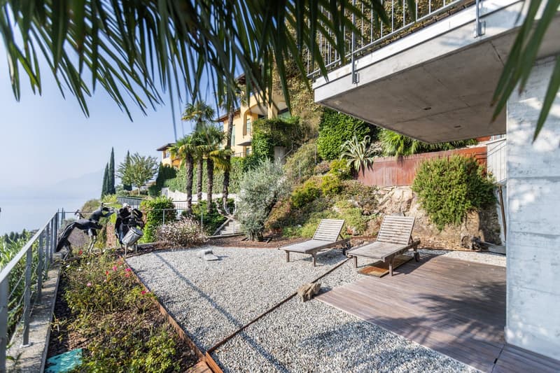 Outdoor area with a gravel patio, wooden deck, lounge chairs, and views of the landscape