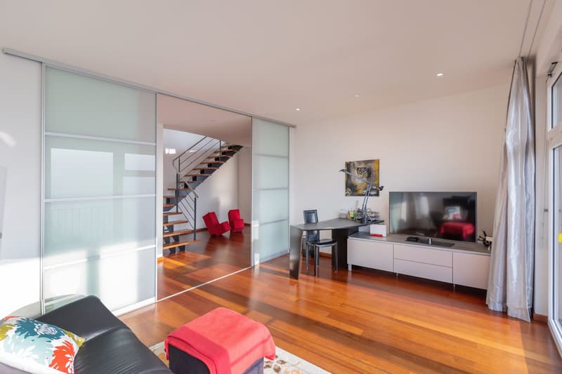 modern living room, sliding glass doors, hardwood floor, staircase, desk, TV, artwork