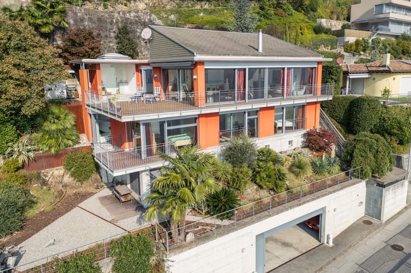 two-story house, orange and white exterior, balcony on each floor, car parked in garage