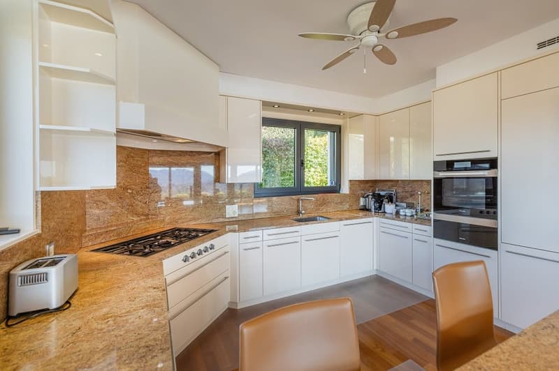 modern kitchen, white cabinets, granite countertops, gas stove, oven, dishwasher, toaster, ceiling fan