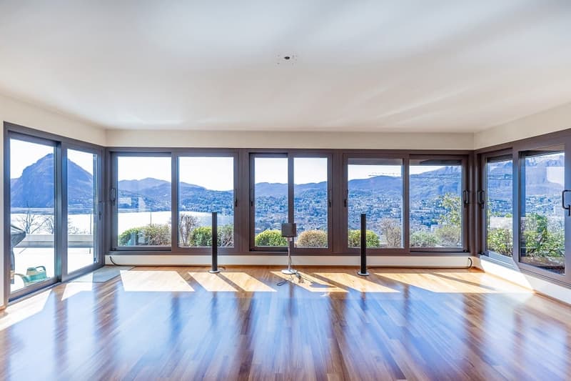 large windows, wooden floor, speakers, view of mountains and lake