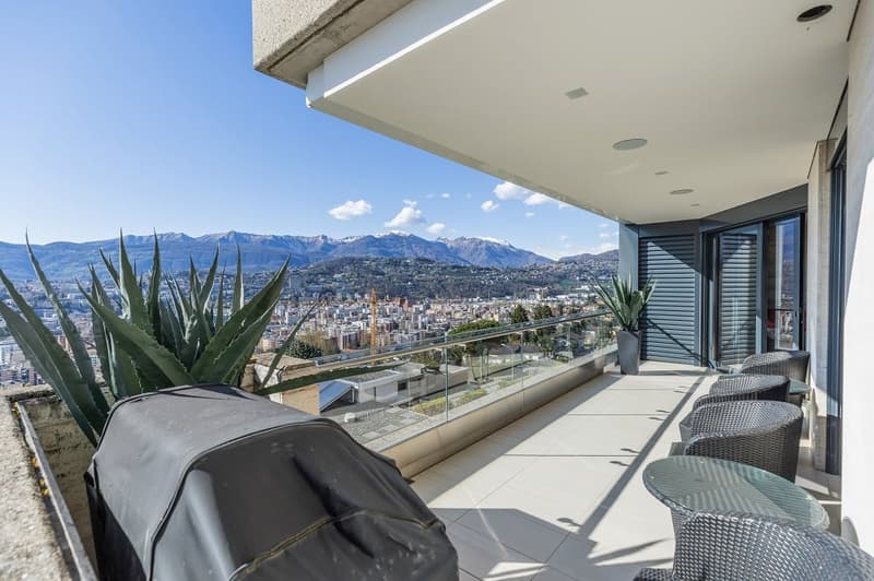 balcony with glass railing, covered with white tiles, outdoor furniture, plants, city view