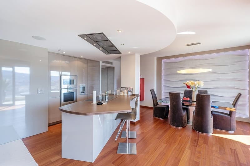 modern kitchen with island, dining area with table and chairs, wooden floor, white walls, modern appliances