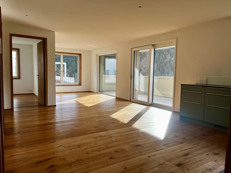 large open space, hardwood floors, sliding glass doors leading to balcony, minimalist