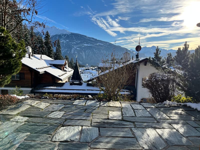 Snow-covered mountain village, wooden houses, winter scenery, clear blue sky